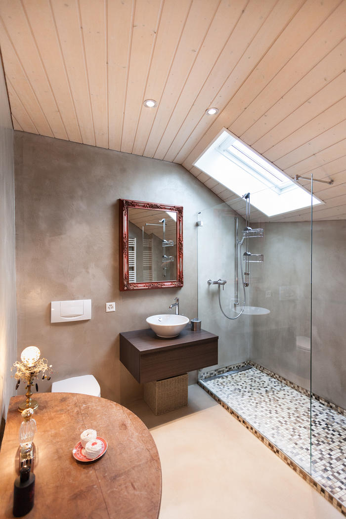 Badezimmer mit gespachtelten Wänden, Holzdecke und begehbarer Dusche